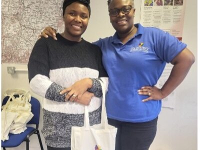 Christmas Party 2023 - Two colleagues sharing Christmas joy with branded gift bags and warm smiles