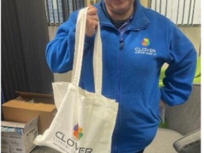 Christmas Party 2023 - Happy team member receiving Clover branded gift bag as Christmas appreciation